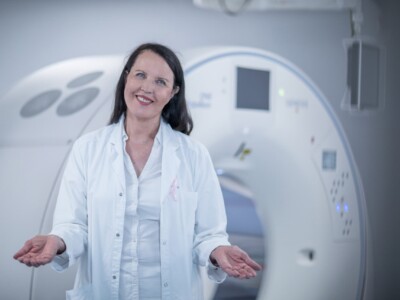 Rintasyöpään erikoistunut plastiikkakirurgi Helena Puonti seisoo TT-kuvasulaitteen edessä ja kertoo että uusi rinta voidaan toisinaan rakentaa jo syöpäleikkauksen yhteydessä.