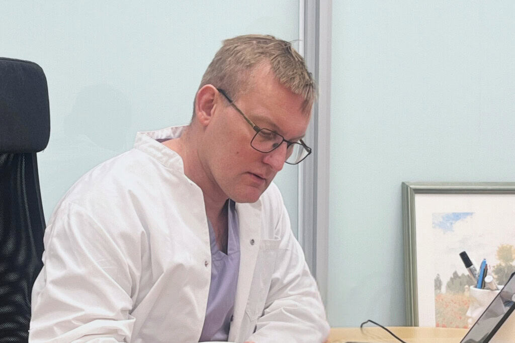 Clinic Helenan lääkäri Timo Halonen tutustuu potilasteksteihin pöytänsä ääerssä